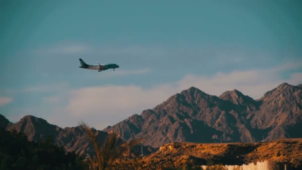 Avion de passagers dans le ciel Atterrissage sur le fond des montagnes et des palmiers en Egypte. Mouvement lent 