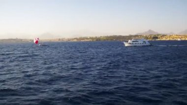 Zevk tekne yüzen Kızıldeniz sahilleri ve plajları Mısır arka plan üzerinde dalgaların üzerinde