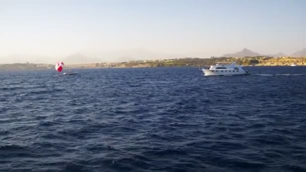 Pleasure Boat Floats on the Waves of the Red Sea on the Background of Coast and Beaches in Egypt — Stock Video