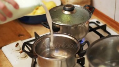 Süt bir eve mutfakta ocakta bir tavaya dökülür. Ağır çekim