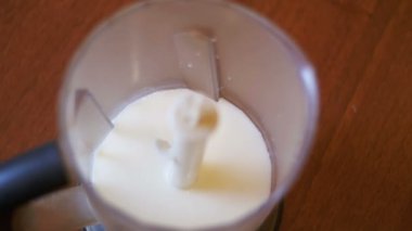 Ev mutfak süt ile bir Blender içine yumurta Falls. Ağır çekim