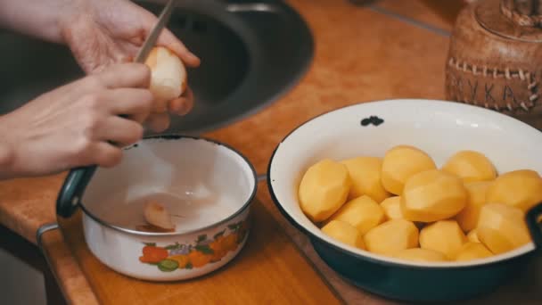 Zenske ruce loupání brambor v domácí kuchyni. Zpomalený pohyb — Stock video