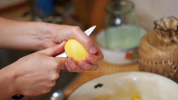 Пилинг картошки на домашней кухне. Slow Motion — стоковое видео
