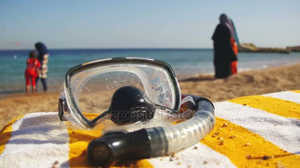 Tauchermaske mit einem Schlauch zum Schnorcheln liegend auf einer Liege vor dem Hintergrund des Strandes am Roten Meer in Ägypten — Stockvideo