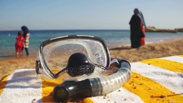 Duikbril met een buis voor snorkelen liggend op een ligstoel op de achtergrond van de rode zee strand in Egypte — Stockvideo