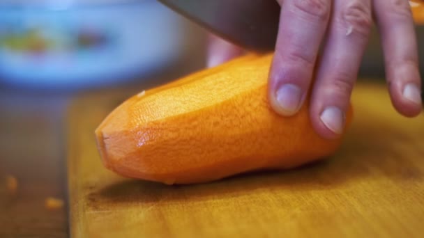 Corte de cenouras em fatias na tábua de corte na cozinha doméstica. Movimento lento — Vídeo de Stock