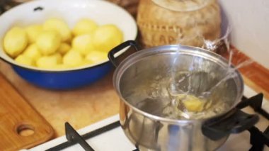 Patates sinekler kaynar su ev mutfakta bir pota. Ağır çekim.