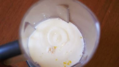 Ev mutfak süt ile bir Blender içine yumurta Falls. Ağır çekim