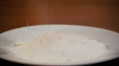 Yumurta bir kapta unu yavaş hareket ile düşüyor