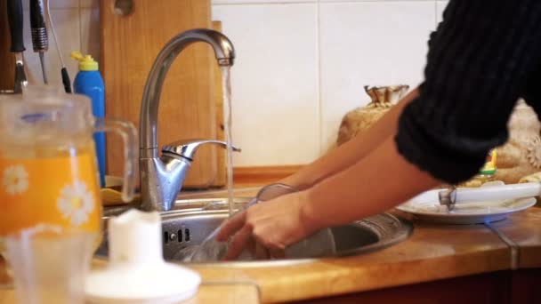 Frau spült Geschirr in der heimischen Küche. Zeitlupe — Stockvideo