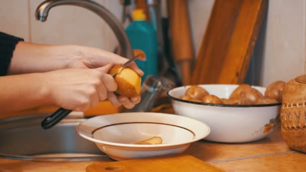 Aardappelen in de binnenlandse keuken schoonmaken — Stockvideo