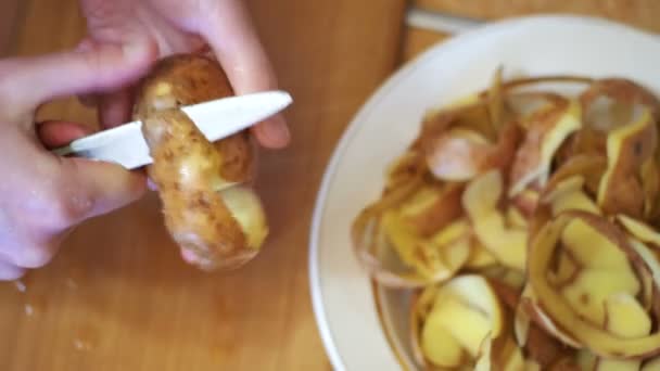 Чистка картоплі на домашній кухні — стокове відео