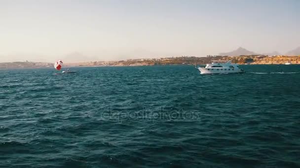 Barco de prazer flutua nas ondas do Mar Vermelho no fundo da costa e praias no Egito — Vídeo de Stock