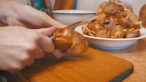 Очистка картофеля на домашней кухне — стоковое видео