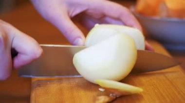 Kadın Şef ev bir mutfak ahşap doğrama tahtası üzerinde soğan dilimlenmiş