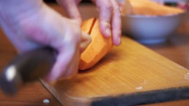 Bir bıçak ile kadın el Ahşap mutfak tahtası ev bir mutfak bıçağı ile havuç dilimleri