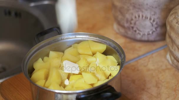 Pedazo de mantequilla cae en las papas en una cacerola en la cocina casera — Vídeo de stock