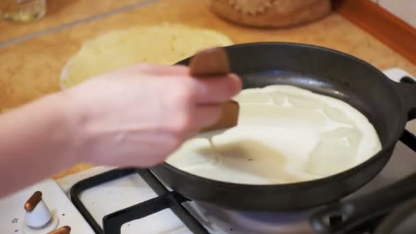 Приготування млинців тісто, квартира торти на гарячі сковороду на домашній кухні — стокове відео
