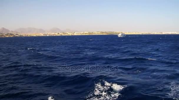 Vergnügungsboot schwimmt auf den Wellen des Roten Meeres vor dem Hintergrund der Küste und Strände in Ägypten — Stockvideo