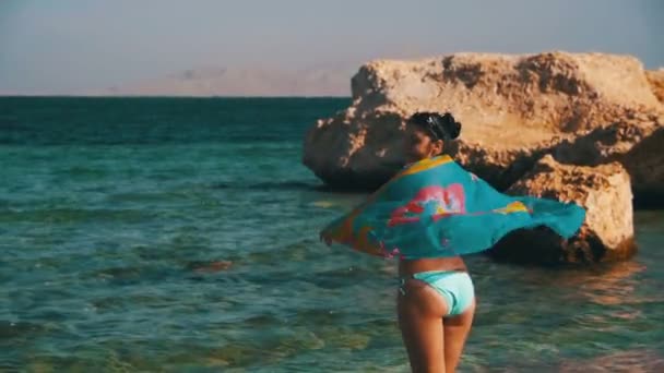 Glückliche Frau mit Schal spaziert in Zeitlupe am Sommerstrand — Stockvideo