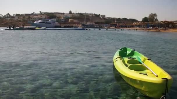 Лодка привязана к пирсу в Красном море на фоне пляжа — стоковое видео