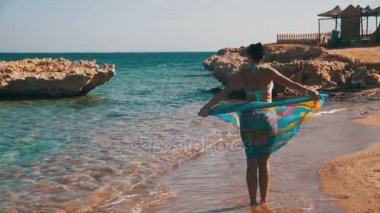 Ağır çekimde yaz sahilde yürüyüş eşarp ile mutlu kadın