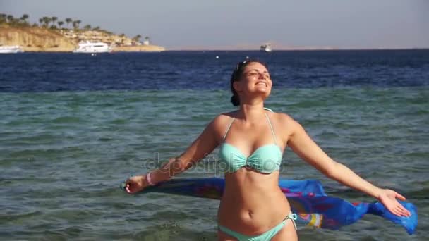 Mujer feliz con bufanda caminando en la playa de verano en cámara lenta — Vídeo de stock