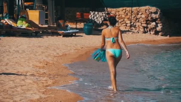 Glückliches Mädchen mit Schal, das am Sommerstrand im roten Meer spaziert. Zeitlupe — Stockvideo