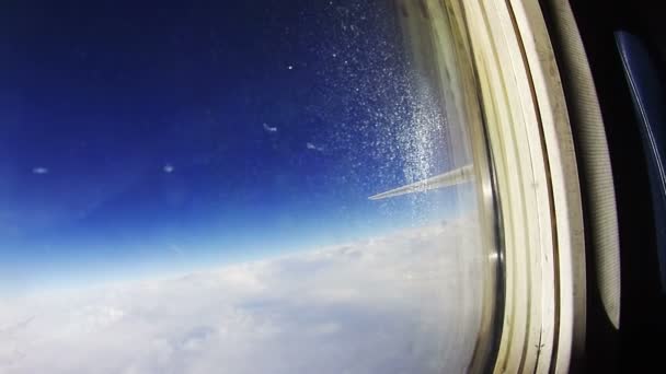 Blick aus einem Flugzeugfenster über den Wolken — Stockvideo