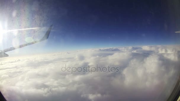 Облака, видимые через окно реактивного самолета — стоковое видео