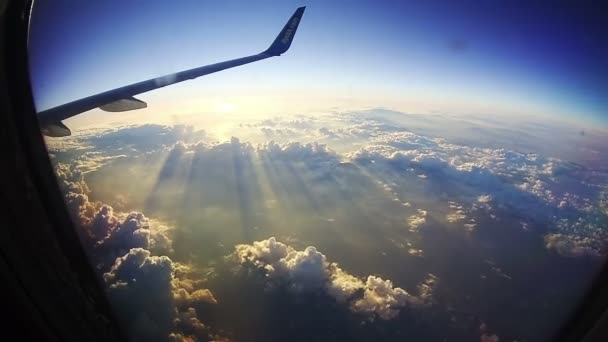 Viaggiare in aereo. Vista attraverso la finestra dell'aereo sullo sfondo del sole — Video Stock