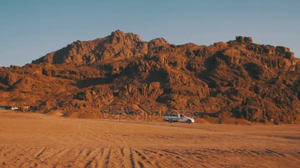 Pickup truck moves Through the Desert in Egypt, on Sand and Mountains Background — Stock Video