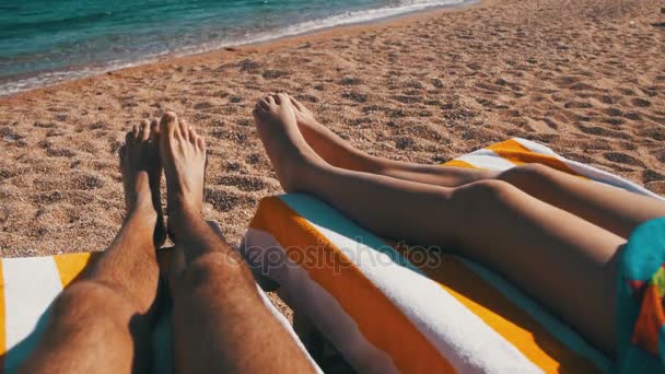 Piernas de Pareja tumbadas en la playa Sun Lounger cerca del Mar Rojo — Vídeos de Stock