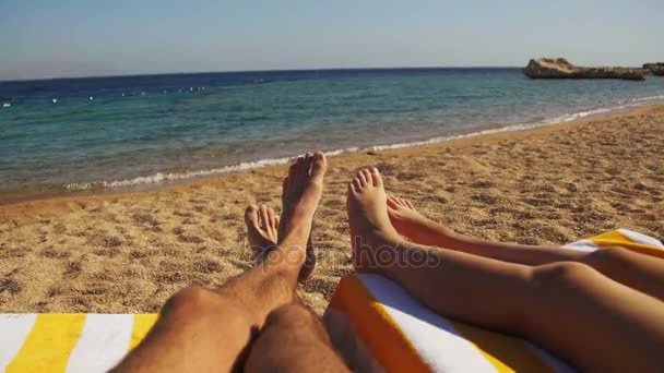 Pernas de Casal Pessoas deitadas na praia Sun Lounger perto do Mar Vermelho — Vídeo de Stock