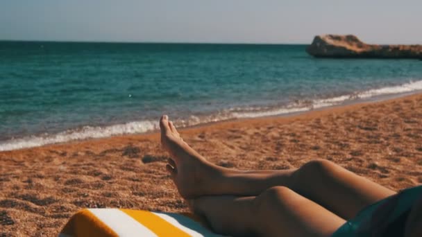 Pernas de mulher deitada na praia Sun Lounger perto do Mar Vermelho, Egito — Vídeo de Stock