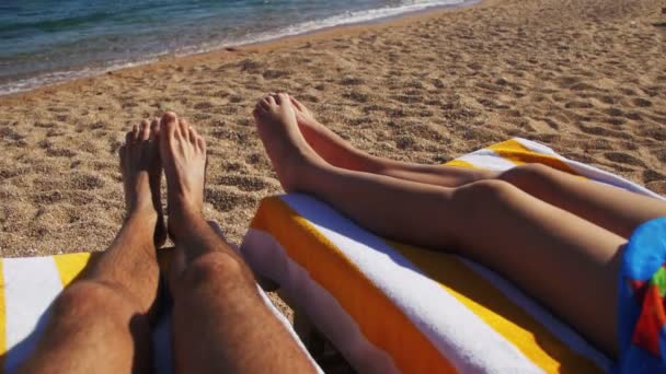 Piernas de Pareja tumbadas en la playa Sun Lounger cerca del Mar Rojo — Vídeo de stock