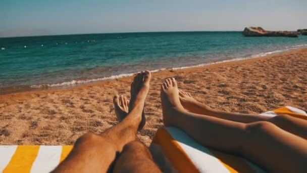 Piernas de Pareja tumbadas en la playa Sun Lounger cerca del Mar Rojo — Vídeo de stock