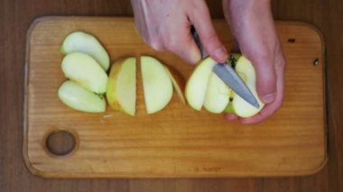 Ev bir mutfak ahşap mutfak tahtası Apple kadın elinde bir bıçakla dilimlenmiş