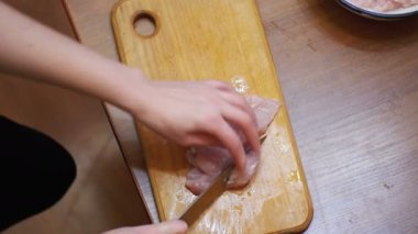 Üstten Görünüm eller taze et çiğ et kesme bir mutfak gemide tavuk fileto kesme, kesme