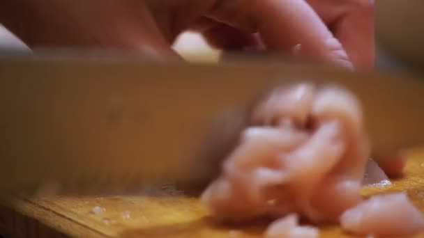 Женские руки с ножом резки мяса на деревянной доске резки на домашней кухне — стоковое видео