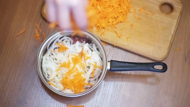 Подготовка пищи с добавлением тертой моркови на домашней кухне. Slow Motion — стоковое видео