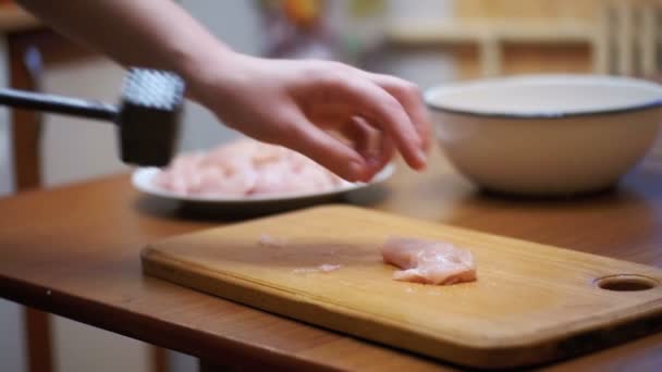 女性調理された新鮮な原料肉をテーブルの上ホーム キッチンで肉ハンマーで打ちます。スローモーション — ストック動画