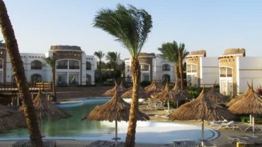 Sunny Hotel Resort mavi Havuzu, palmiye ağaçları ve şezlong Mısır. Zaman atlamalı