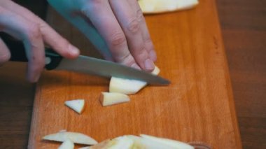 Ev bir mutfak ahşap mutfak tahtası Apple kadın elinde bir bıçakla dilimlenmiş