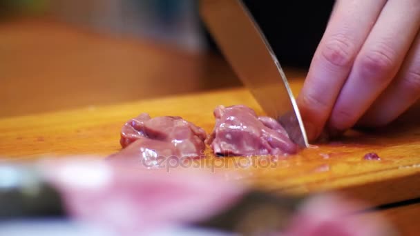 Kvinna kock skivor kyckling lever kött på en trä kök ombord i hem kök. — Stockvideo
