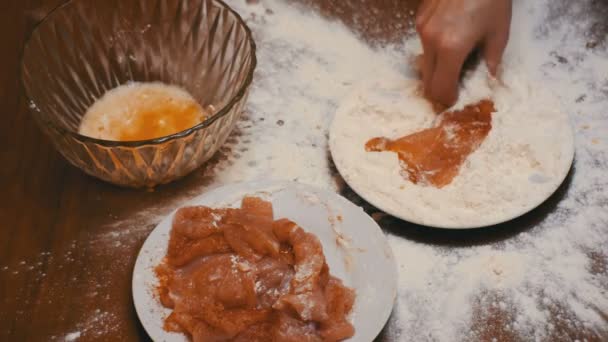 Vedere de sus a bucății de carne cade pe o farfurie de făină în bucătăria de acasă — Videoclip de stoc