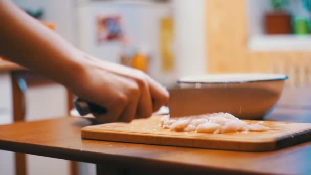 Mani di donna con un coltello Tagliare la carne su un tagliere di legno nella cucina di casa. Rallentatore — Video Stock