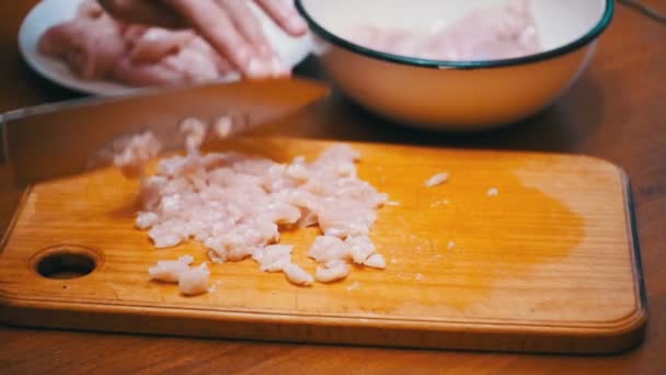 Manos de mujer con un cuchillo en rodajas de carne en una tabla de cortar de madera en la cocina casera. Moción lenta — Vídeos de Stock