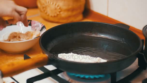Готовить мясные отбивные на сковородке на домашней кухне — стоковое видео
