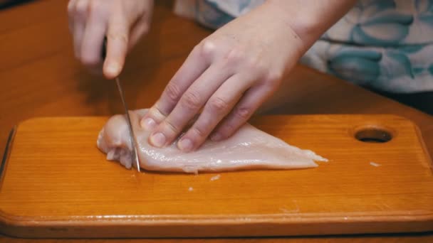 Manos Cortando Carne Fresca, Cortando Filete de Pollo en una Junta de Cocina, Cortando Carne Cruda — Vídeo de stock